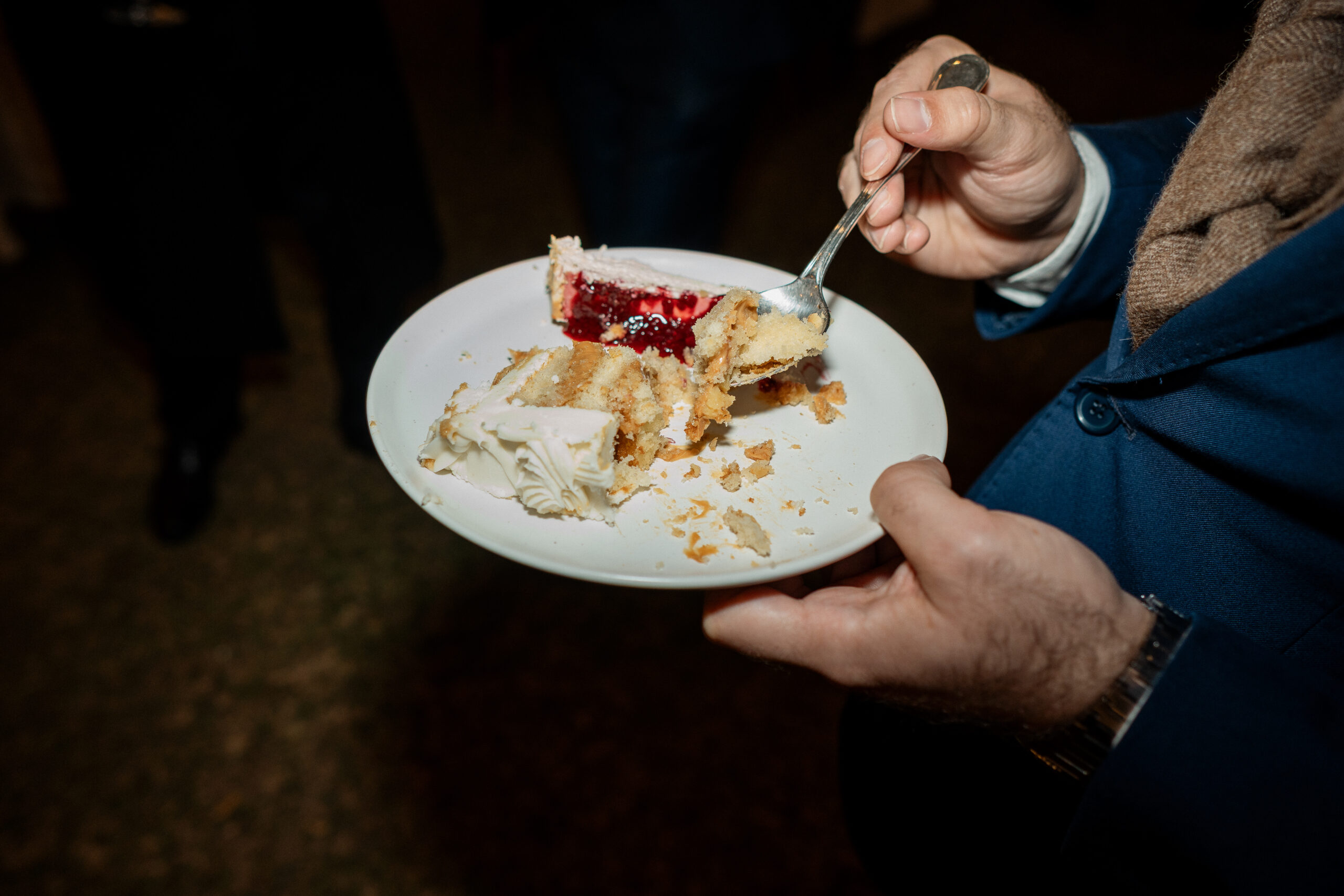 Um pedaço de bolo de casamento na mão de um cliente